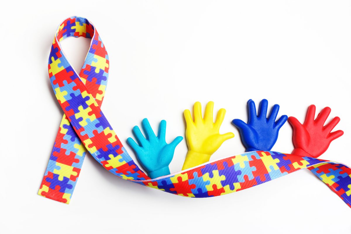 GettyImages-929003432 A colorful ribbon and three hands on top of it.