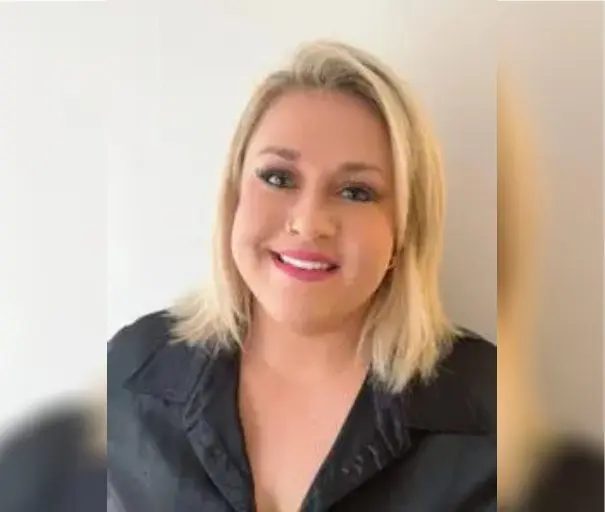 image Smiling woman with blonde hair and black shirt.